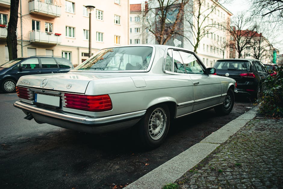Vintage Mercedes-Benz 280 SLC automobile parked in a city street setting, showcasing classic elegance.